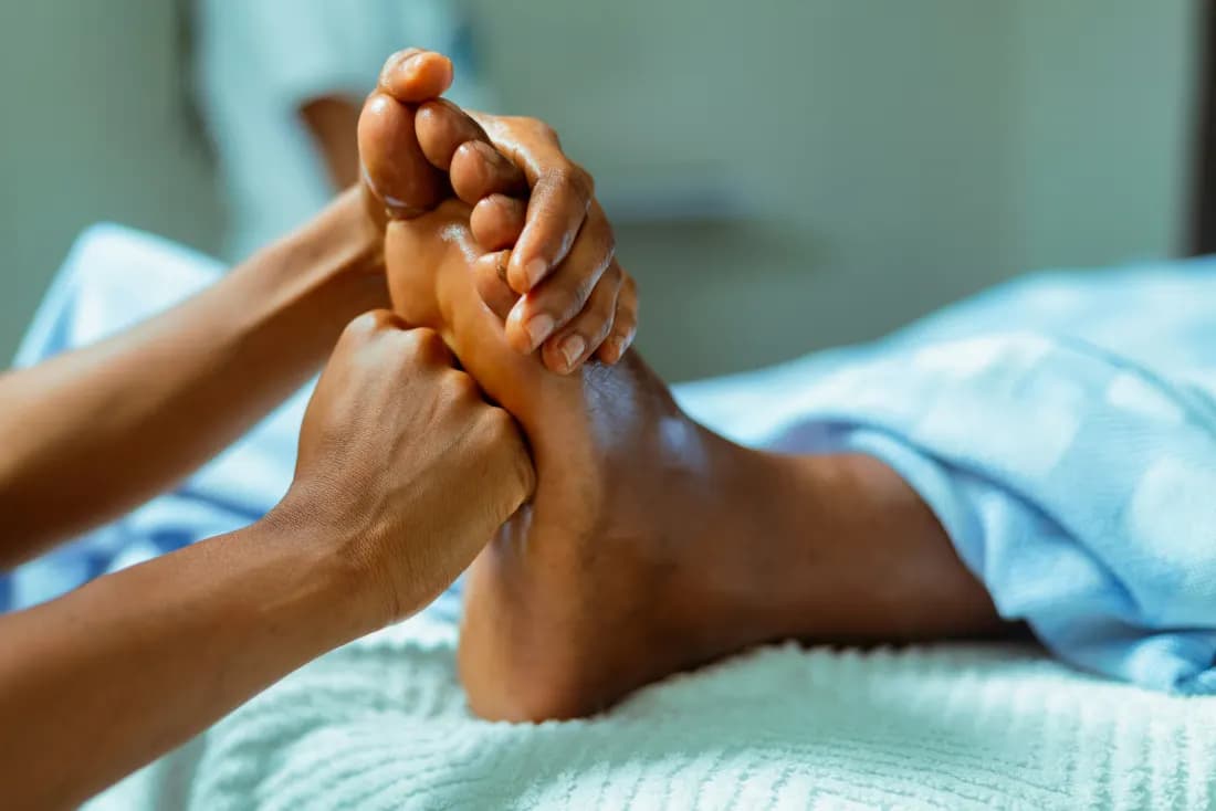 Both hands working the arch of an athlete's foot
